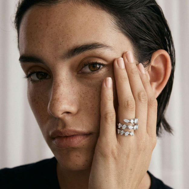 Woman wearing a diamond ring with a neutral background