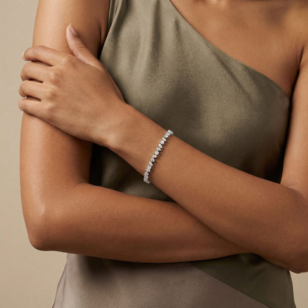 Woman wearing a silver bracelet on a beige background