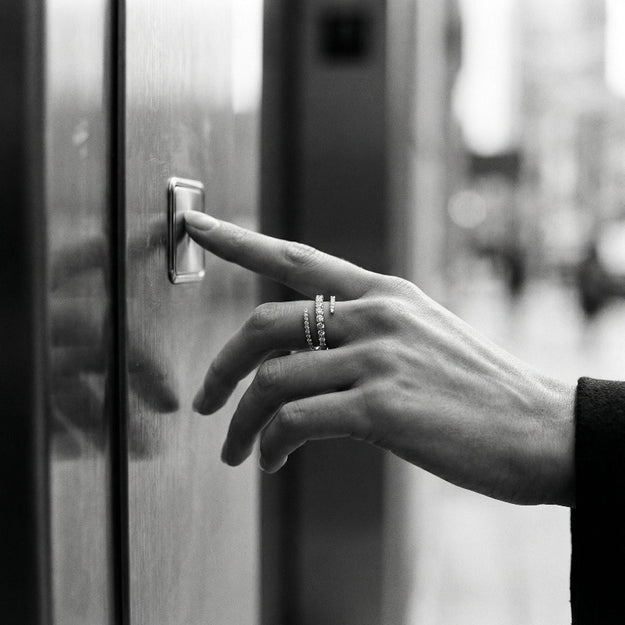Hand pressing a doorbell button with a blurred background