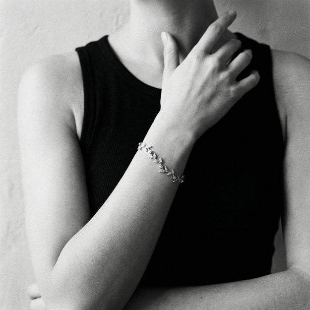 Person wearing a delicate bracelet on a plain background