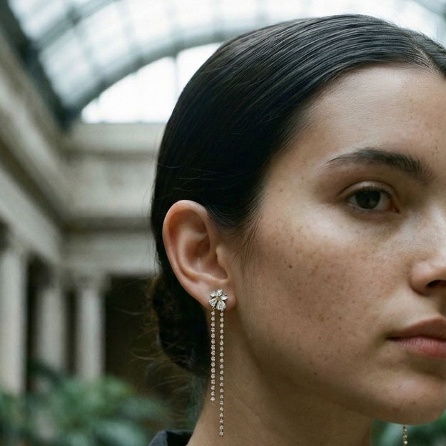 Woman wearing earrings in an indoor setting with columns and plants