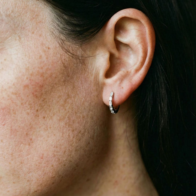 Close-up of an ear with a diamond hoop earring.