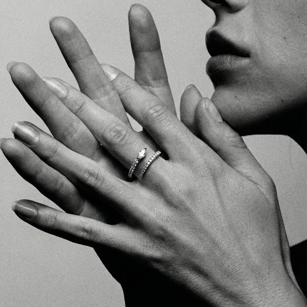Close-up of a hand wearing a ring with a neutral background