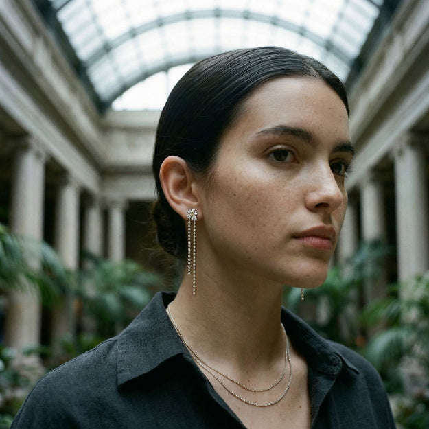 Woman wearing earrings in an indoor setting with columns and plants